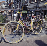 852104 Afbeelding van een bont geschilderde fiets tegen de balustrade van de Maartensbrug over de Oudegracht te ...